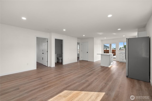 unfurnished living room with light wood-style floors, baseboards, and recessed lighting