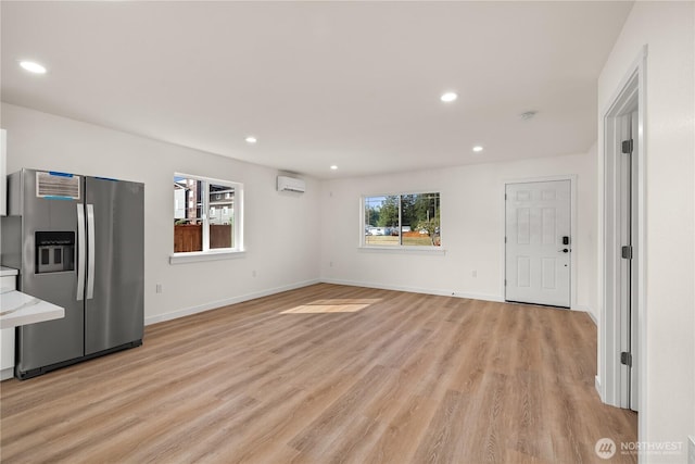 unfurnished living room with a wealth of natural light, light wood-style flooring, and recessed lighting