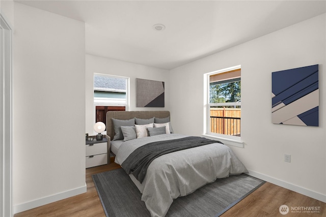 bedroom with baseboards and wood finished floors