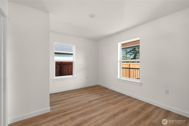 empty room with baseboards and wood finished floors