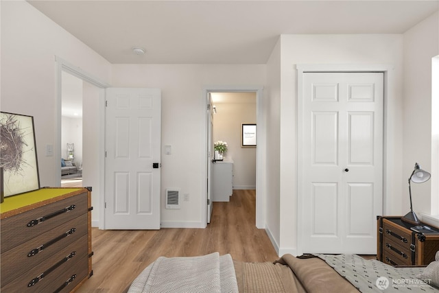 bedroom with visible vents, a closet, light wood-style flooring, and baseboards