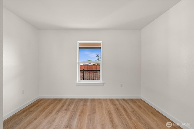 unfurnished room with light wood-style flooring and baseboards