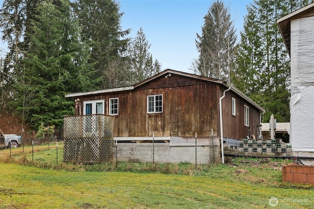 view of home's exterior featuring fence and a lawn