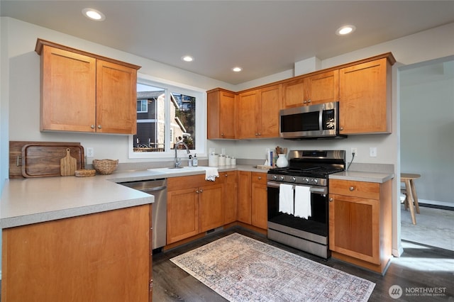 kitchen featuring recessed lighting, stainless steel appliances, a sink, and light countertops