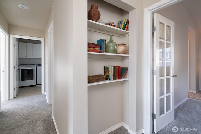 corridor with built in features, washing machine and dryer, carpet flooring, and baseboards