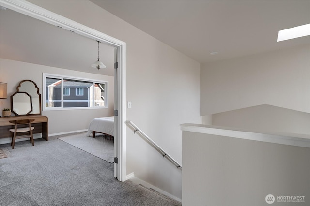 interior space with carpet floors, baseboards, and an upstairs landing