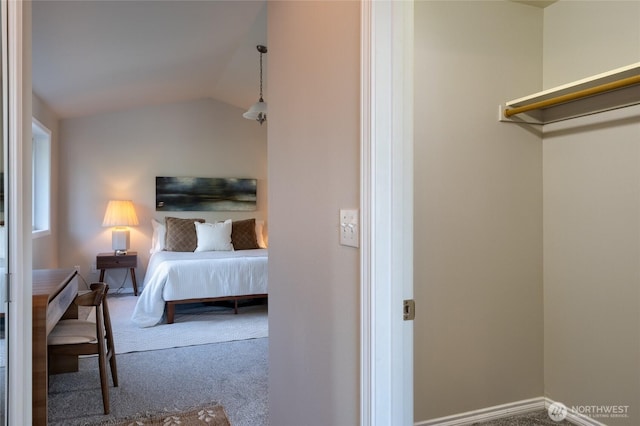 carpeted bedroom featuring baseboards and vaulted ceiling