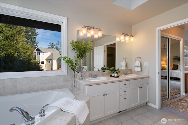 ensuite bathroom with double vanity, tile patterned flooring, a sink, and connected bathroom