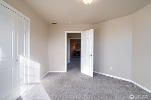 unfurnished bedroom featuring carpet, visible vents, and baseboards