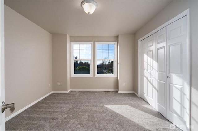 unfurnished bedroom featuring carpet, a closet, and baseboards