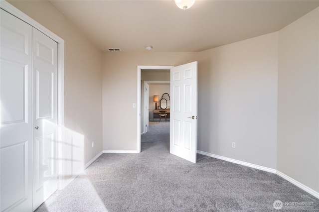 unfurnished bedroom with carpet floors, visible vents, and baseboards