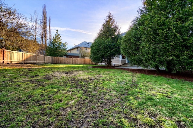 view of yard featuring entry steps and fence