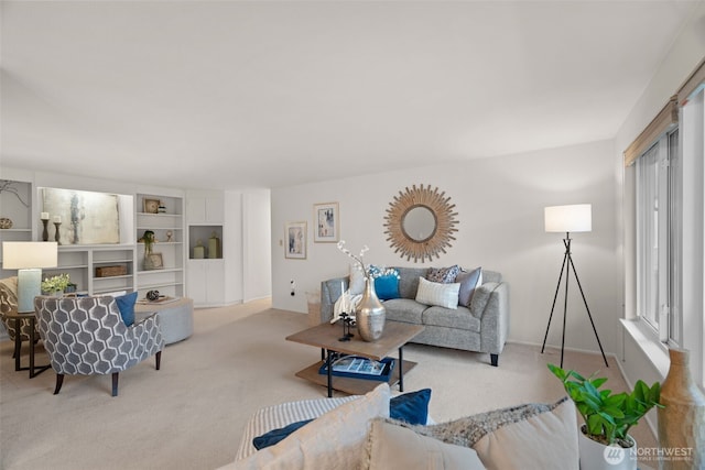 carpeted living area featuring baseboards