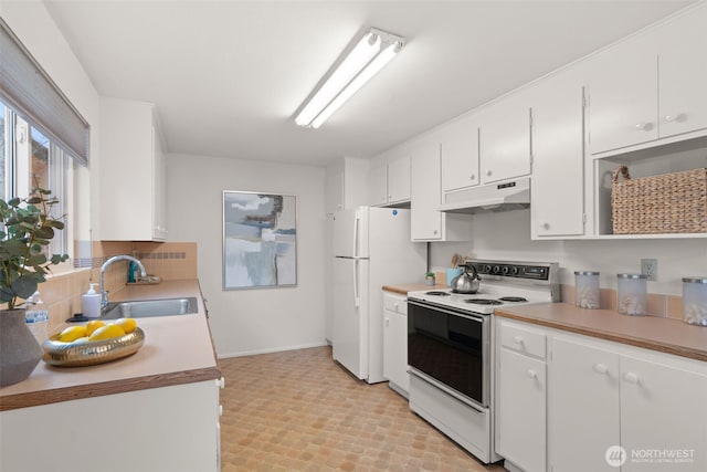 kitchen featuring white appliances, under cabinet range hood, white cabinets, and a sink