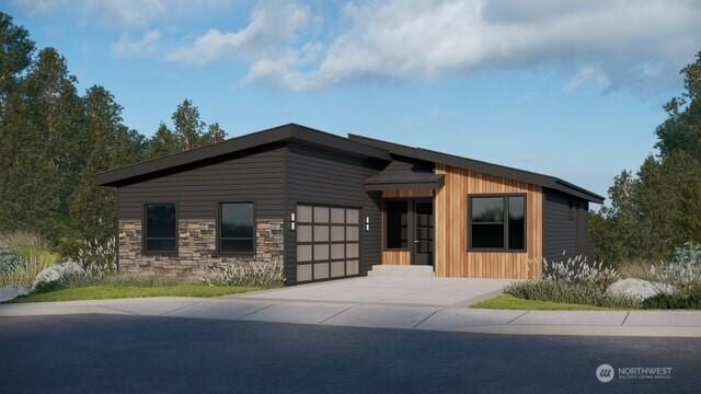 view of front of house with a garage, concrete driveway, and stone siding