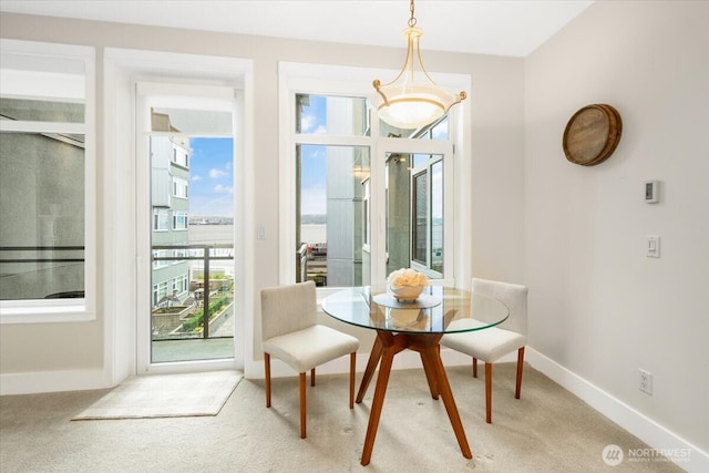 carpeted dining room with baseboards