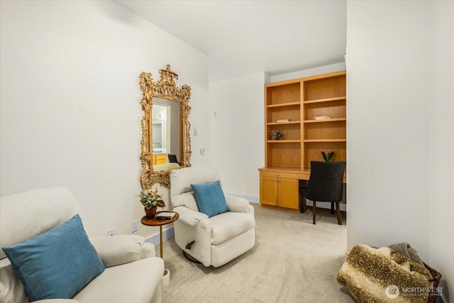 living area with built in study area and light colored carpet