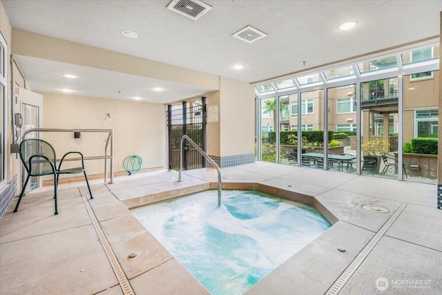 view of swimming pool with an indoor hot tub