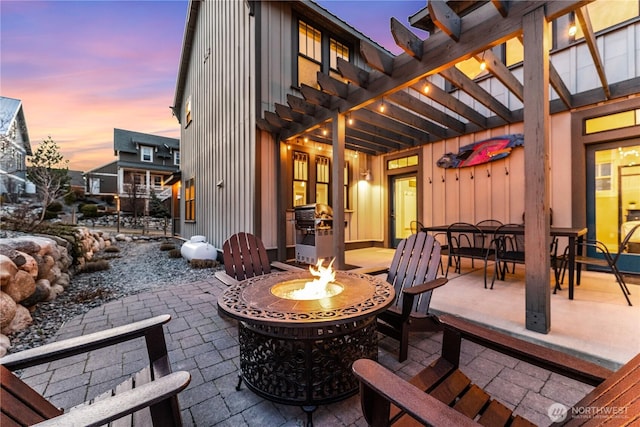 view of patio featuring an outdoor fire pit, outdoor dining area, area for grilling, and a pergola