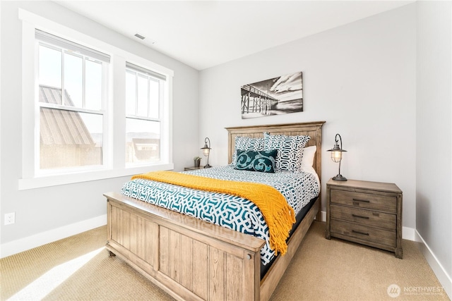 bedroom with light colored carpet, visible vents, and baseboards