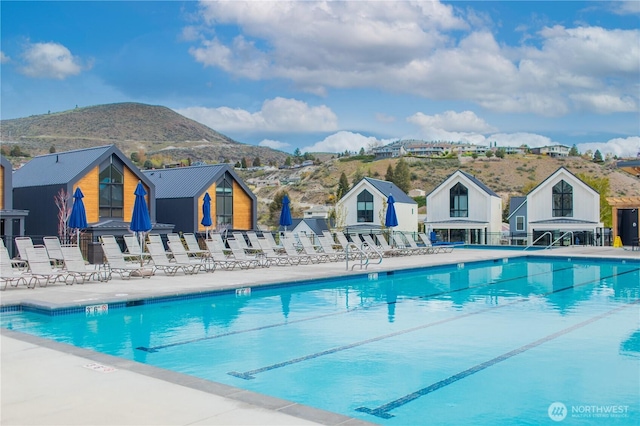 view of swimming pool featuring a residential view, a patio area, a mountain view, and fence