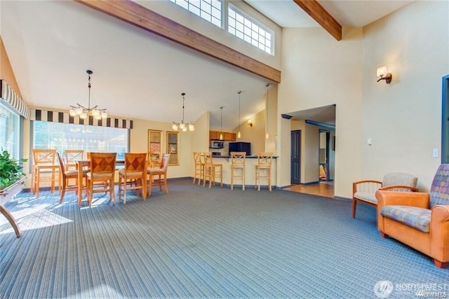 interior space featuring a chandelier, beam ceiling, and a high ceiling