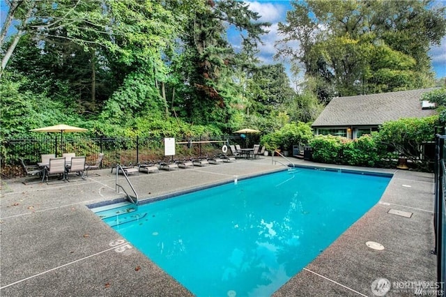 community pool with fence and a patio