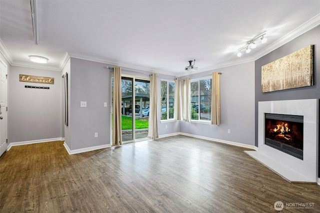 unfurnished living room featuring a fireplace with flush hearth, crown molding, baseboards, and wood finished floors