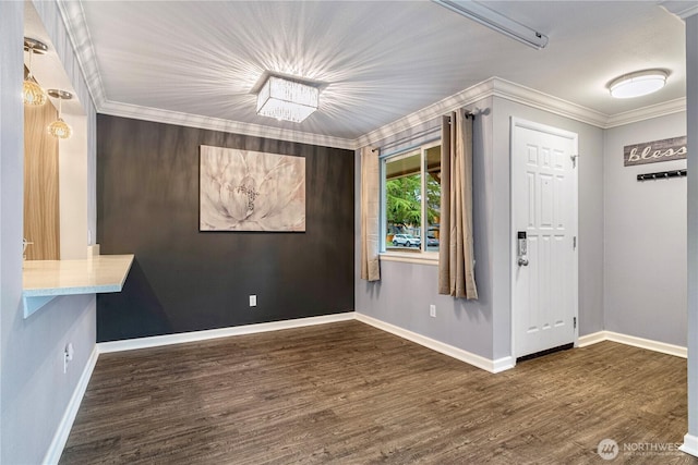 interior space featuring crown molding, baseboards, and wood finished floors