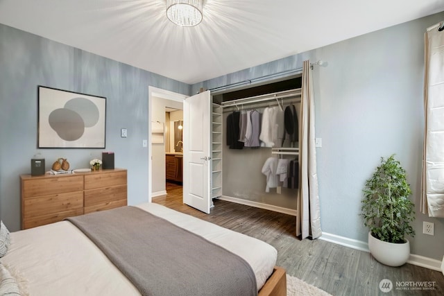 bedroom with a closet, wood finished floors, and baseboards