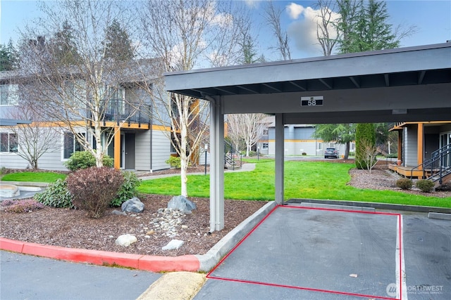 view of community with a yard and covered and uncovered parking