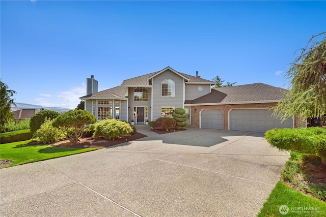 traditional home with a garage, brick siding, driveway, and a chimney