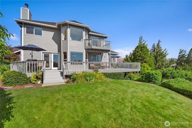 back of property featuring french doors, a lawn, a chimney, and a balcony