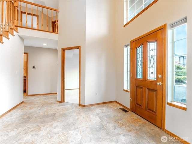 entryway featuring a high ceiling, visible vents, and baseboards