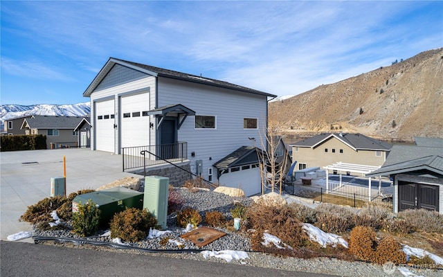 view of front of home featuring a mountain view, a detached garage, and fence