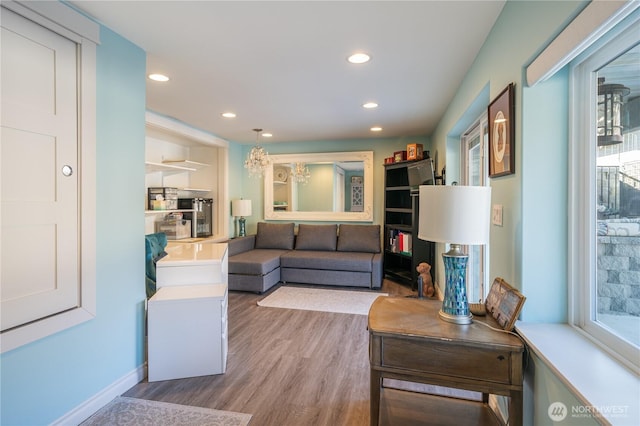 living area featuring recessed lighting, baseboards, and wood finished floors