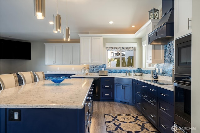 kitchen with a sink, black appliances, blue cabinets, and premium range hood