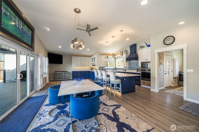 dining room featuring baseboards, dark wood finished floors, recessed lighting, ceiling fan, and vaulted ceiling