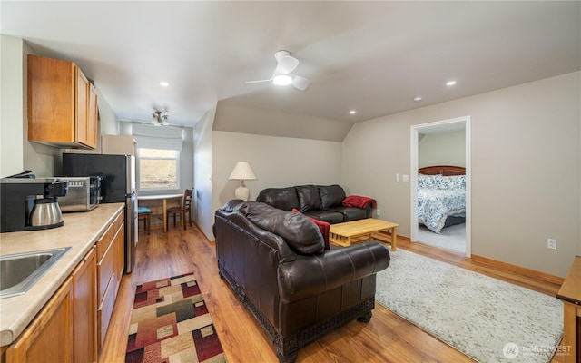 living area with recessed lighting, ceiling fan, vaulted ceiling, and light wood finished floors