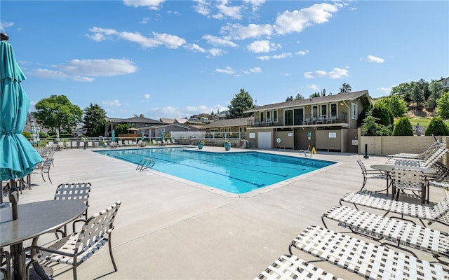 community pool featuring a patio and fence