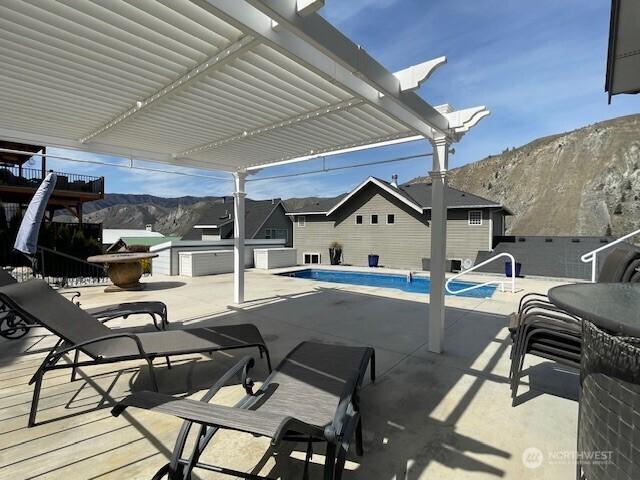 view of patio featuring a pergola, a mountain view, and a fenced in pool