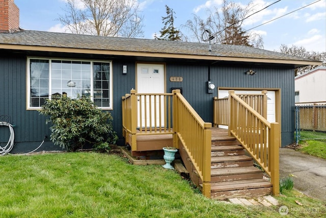 view of exterior entry with a lawn, a chimney, and fence