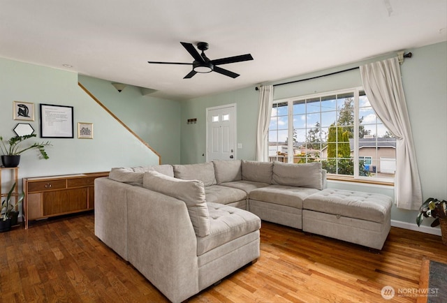 living area with a ceiling fan and wood finished floors