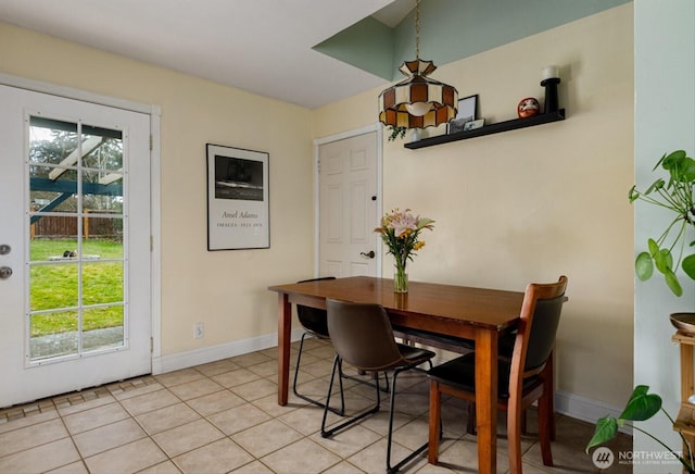 dining space featuring light tile patterned flooring and baseboards