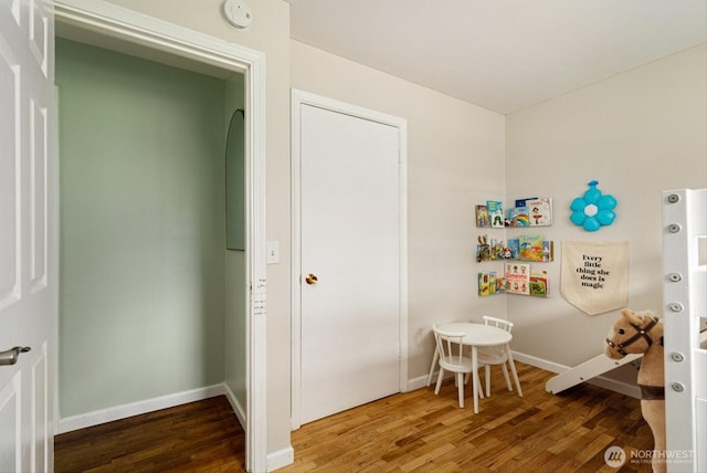 interior space with baseboards and wood finished floors