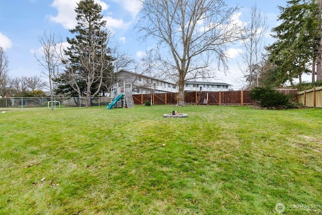 view of yard featuring a fenced backyard and a playground