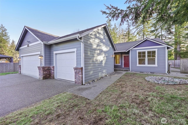 ranch-style house with aphalt driveway, brick siding, an attached garage, and fence