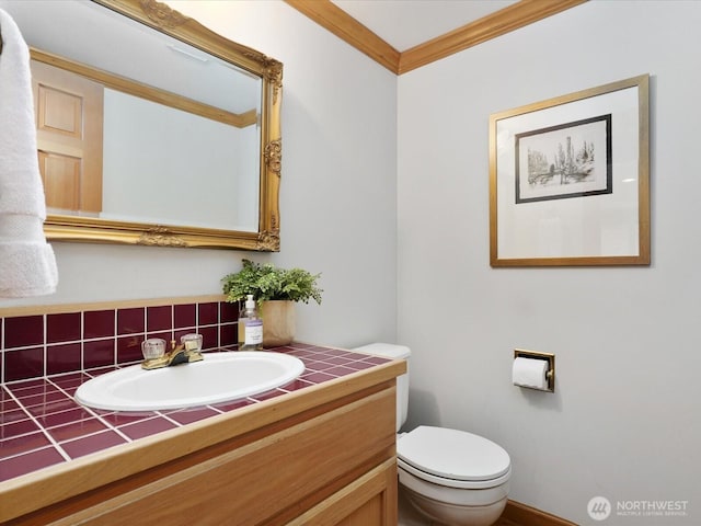 bathroom featuring toilet, crown molding, and vanity