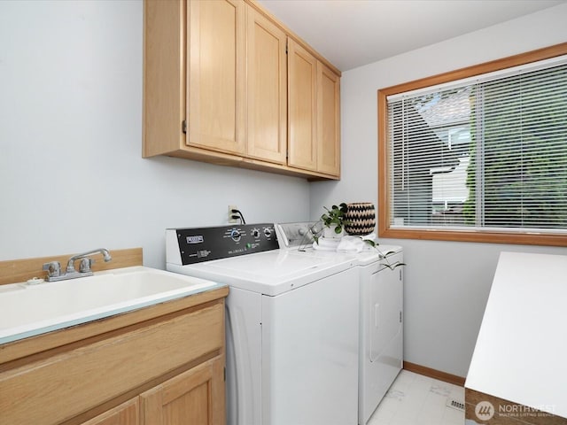 laundry area featuring cabinet space, baseboards, a sink, and independent washer and dryer