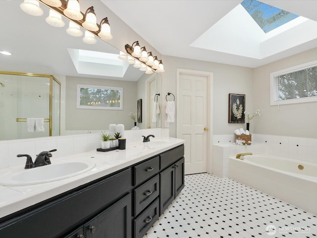 bathroom with a skylight, a sink, a bath, and a shower stall